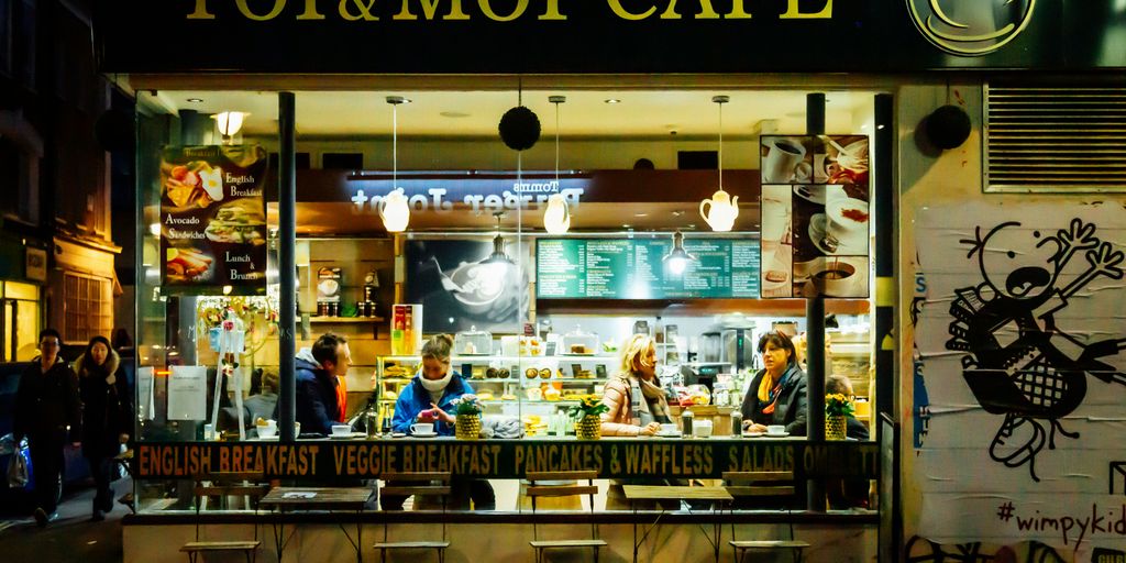 people standing in front of brown and white wooden store